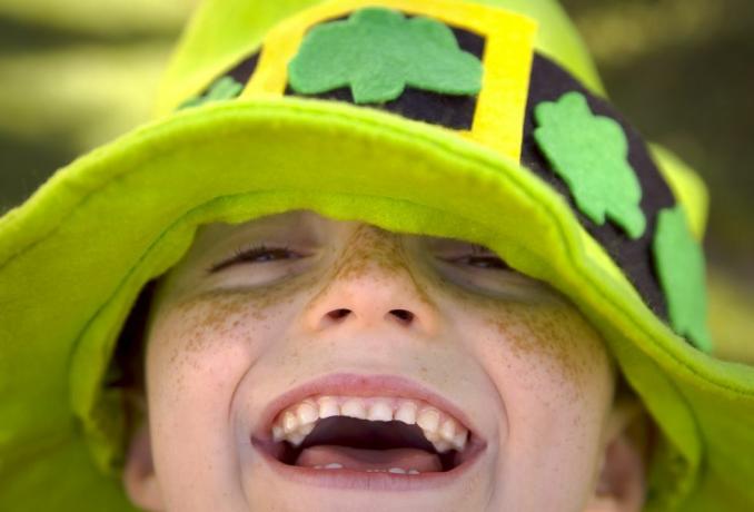 Aziz Patrick Günü'nde, şirin bir resim yazısına ihtiyaç duyan, yoncalı, siperlikli yeşil giyen gülümseyen çilli çocuğun yakın çekimi