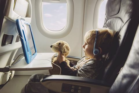 Dijital tablet bir şey izlerken bir uçakta oturan küçük çocuk