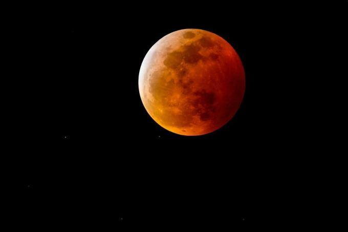 gece gökyüzünde tam bir ay tutulması nedeniyle kırmızımsı gölgeli bir kanlı ay veya dolunay