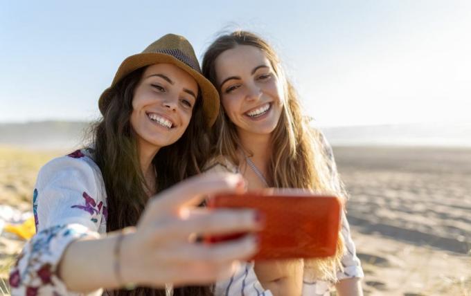 en iyi iki arkadaş sahilde akıllı telefonla selfie çekiyor