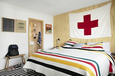 çizgili yorgan ve büyük kırmızı haç bayrağı ile ev sahibi raili clasen yatak odası