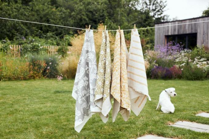 Bahçedeki çamaşır ipinden asılı kök boya Cutch Co kumaşları