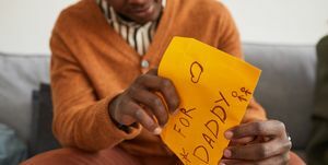 Afro-Amerikan bir adamın babalar günü için el yapımı bir hediye olarak babasına mektup açmasına yakın, kopya alanı