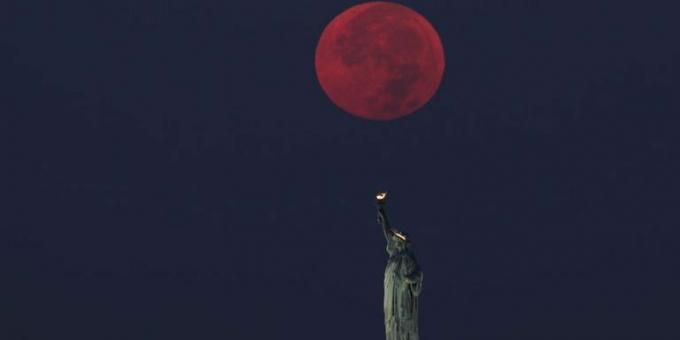 dolunay new york'taki özgürlük heykelinin arkasında batıyor