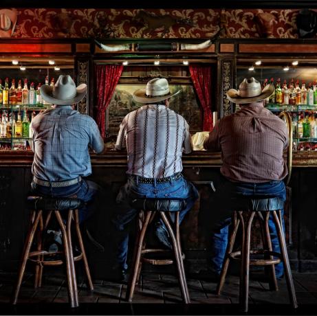 nehir çiftliği barlarındaki barda oturan üç kovboy